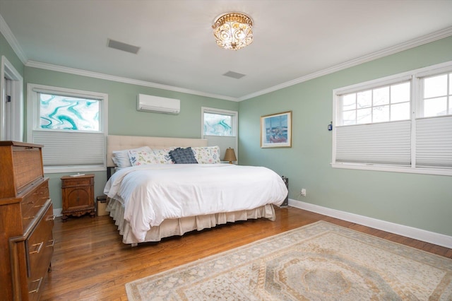 bedroom with a wall mounted AC, crown molding, and hardwood / wood-style flooring