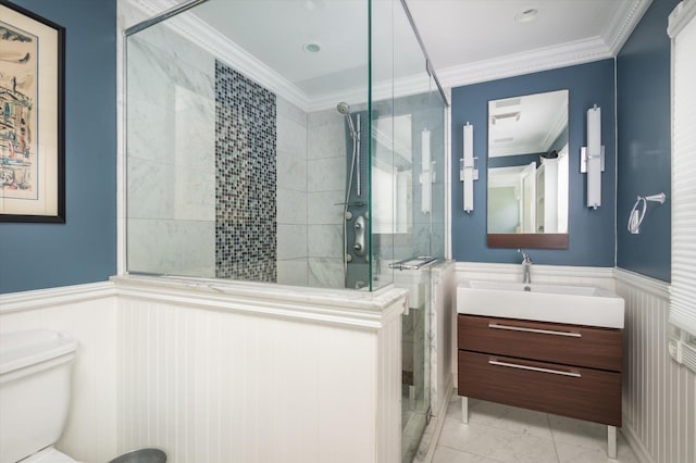 bathroom with tile patterned floors, vanity, a shower with door, crown molding, and toilet