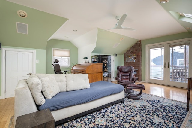 living room featuring ceiling fan, vaulted ceiling, light hardwood / wood-style floors, and french doors