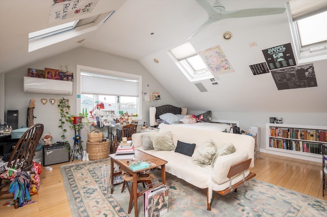 bedroom featuring an AC wall unit, ceiling fan, vaulted ceiling with skylight, and light wood-type flooring