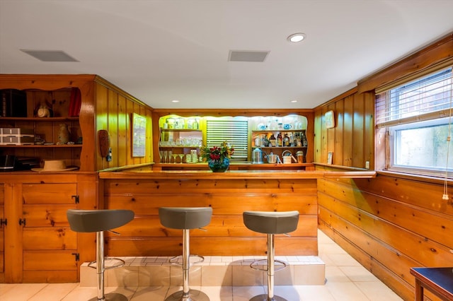 bar featuring wooden walls and light tile patterned flooring