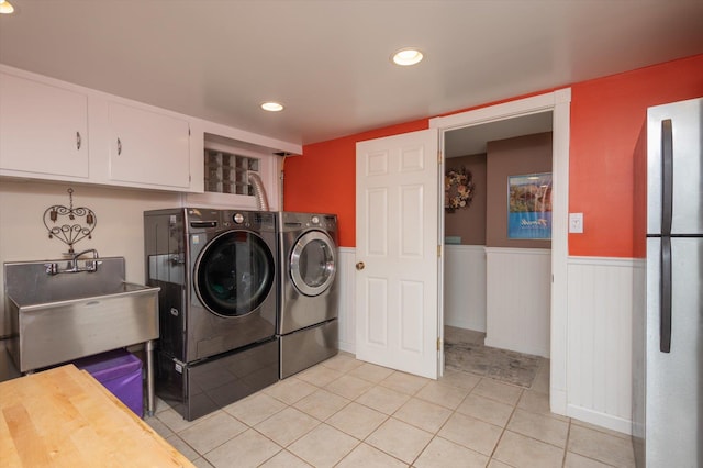 washroom featuring sink, washing machine and dryer, and light tile patterned flooring