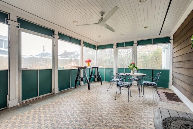 sunroom with a mountain view and ceiling fan