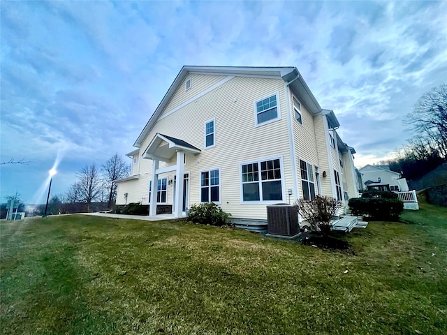 rear view of house featuring a yard and central AC unit