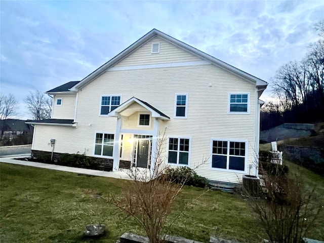 rear view of house with a lawn and central AC