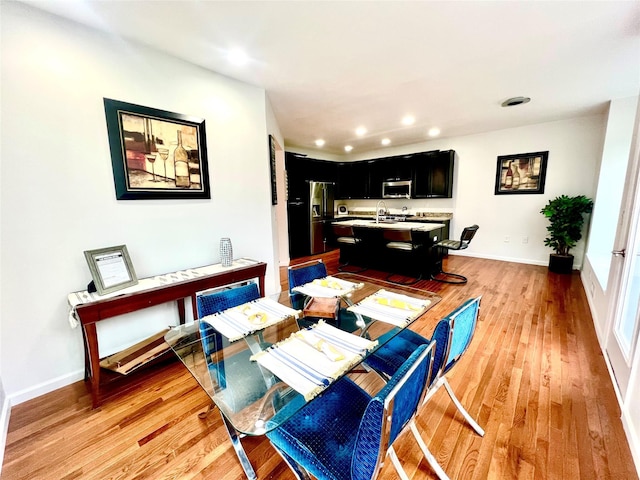 dining area with light wood-type flooring and sink