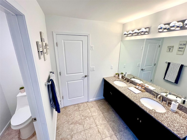 bathroom featuring toilet, vanity, and tile patterned flooring