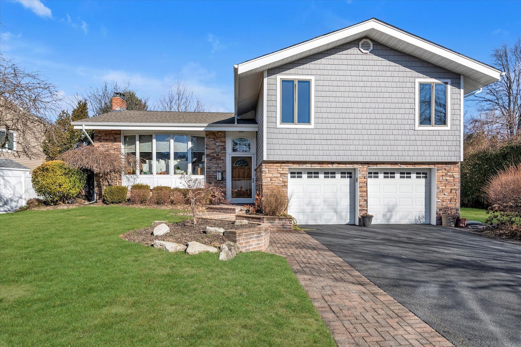 tri-level home with a front yard and a garage