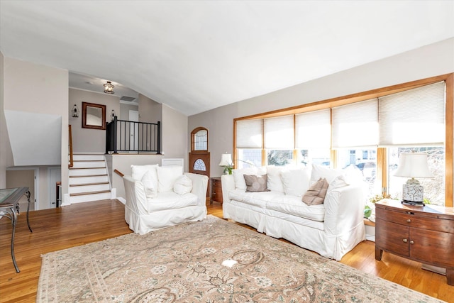 living room with light hardwood / wood-style floors and vaulted ceiling