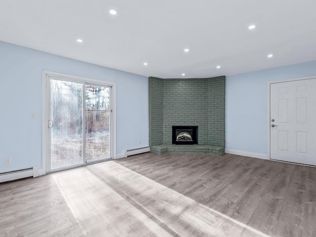 unfurnished living room with a fireplace, light wood-type flooring, and baseboard heating