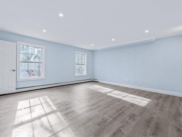 empty room with a baseboard radiator and light wood-type flooring