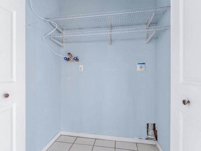 clothes washing area with electric dryer hookup and light tile patterned floors