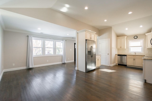 kitchen with lofted ceiling, dark wood-type flooring, ornamental molding, appliances with stainless steel finishes, and tasteful backsplash