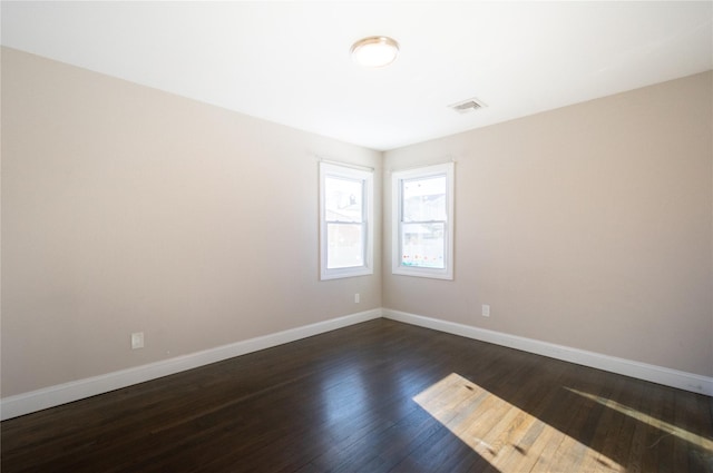 spare room featuring dark wood-type flooring