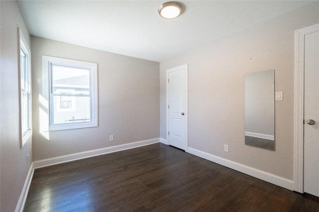 spare room with dark wood-type flooring