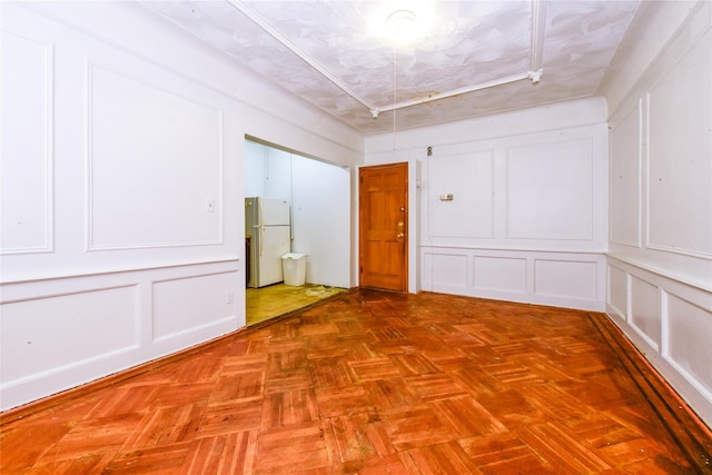 empty room with parquet floors and a textured ceiling