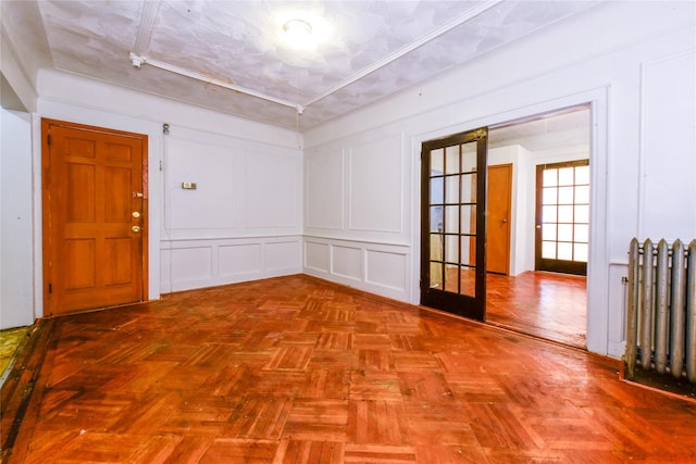 empty room with parquet flooring and radiator