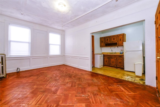 unfurnished dining area with sink and light parquet floors