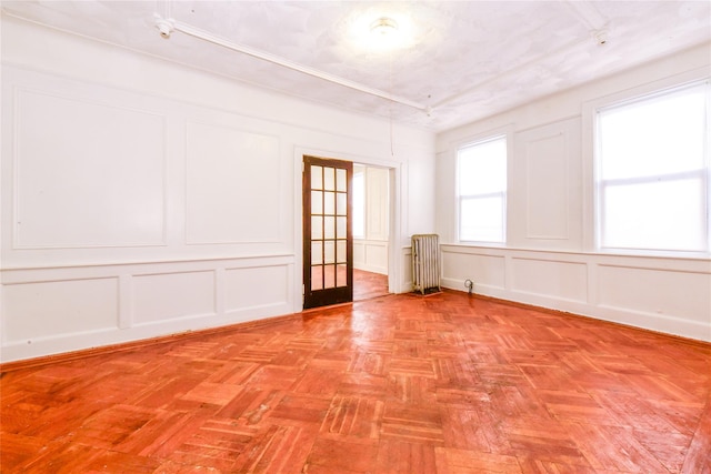 spare room with french doors, radiator, and light parquet floors