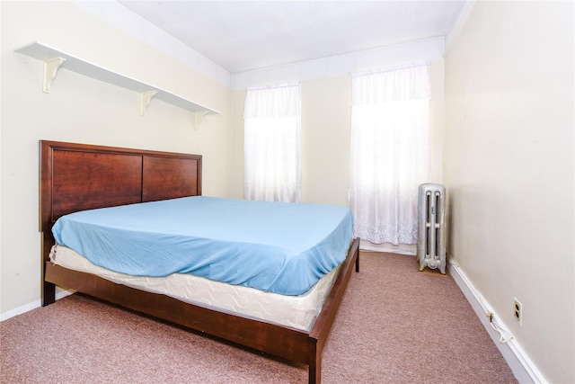 bedroom with radiator and light colored carpet