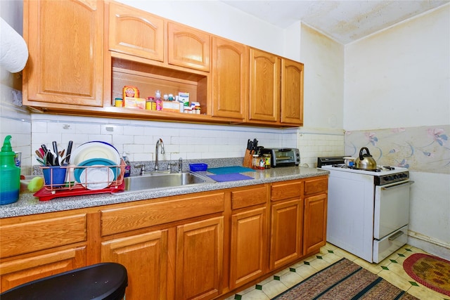 kitchen with light tile patterned floors, sink, white range with gas cooktop, and tasteful backsplash