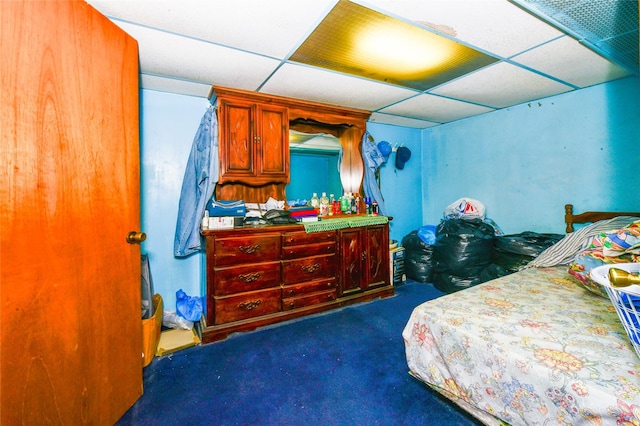 bedroom with dark colored carpet and a drop ceiling