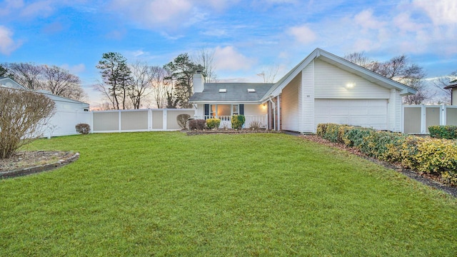 ranch-style home featuring a garage, covered porch, and a front yard