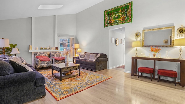 living room with light hardwood / wood-style flooring and a skylight