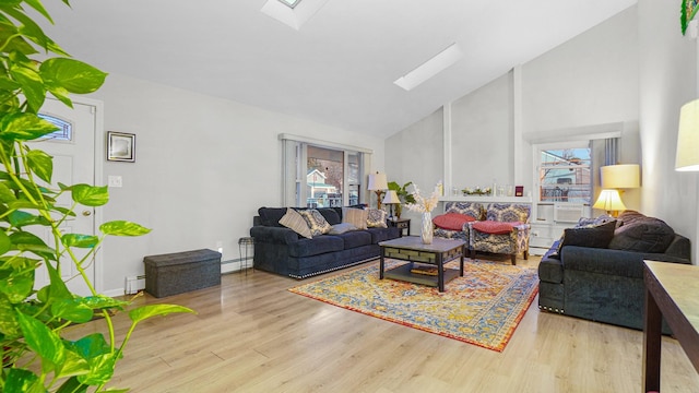 living room featuring light hardwood / wood-style flooring, baseboard heating, high vaulted ceiling, and a skylight