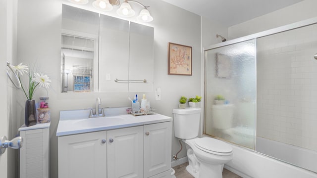 full bathroom with shower / bath combination with glass door, vanity, and toilet