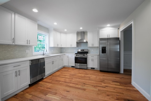 kitchen featuring white cabinetry, sink, wall chimney exhaust hood, and appliances with stainless steel finishes