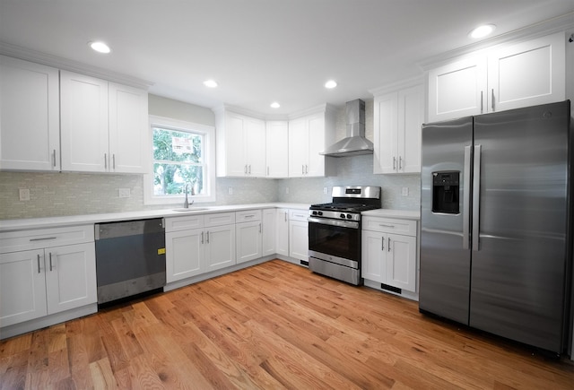 kitchen featuring white cabinets, wall chimney exhaust hood, and stainless steel appliances