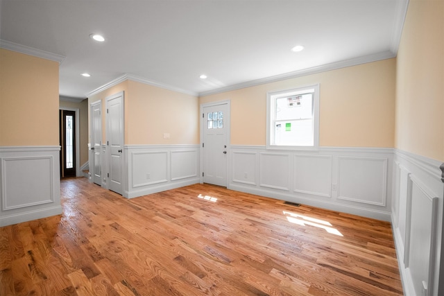 unfurnished room featuring ornamental molding and light hardwood / wood-style flooring