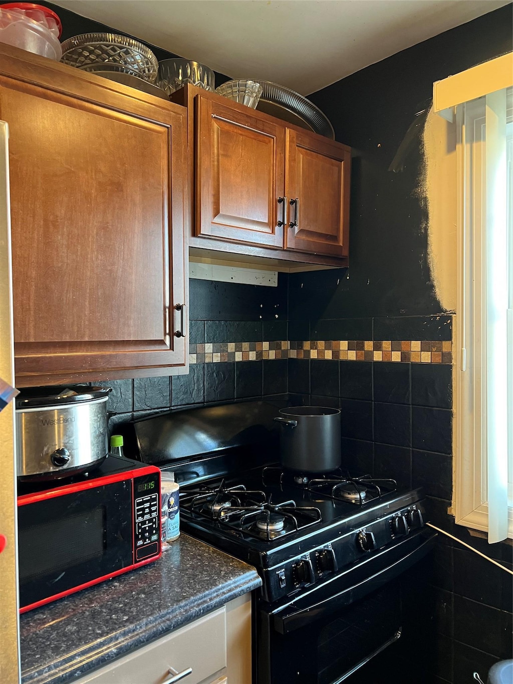 kitchen featuring tasteful backsplash and black appliances