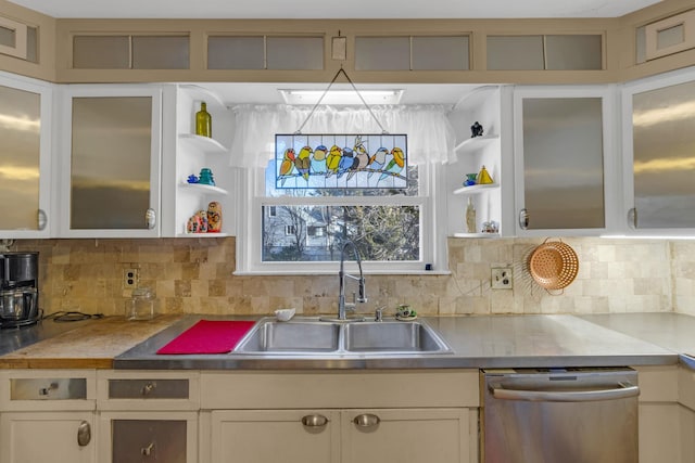 kitchen with backsplash, sink, white cabinets, and stainless steel dishwasher