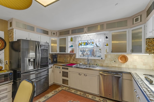 kitchen featuring backsplash, stainless steel appliances, white cabinetry, and sink