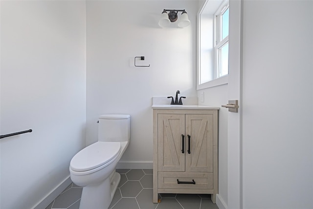 bathroom with tile patterned flooring, vanity, and toilet