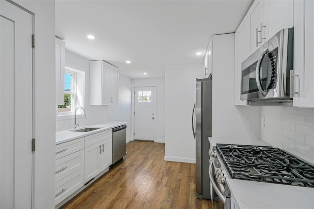 kitchen featuring white cabinets, decorative backsplash, stainless steel appliances, and sink