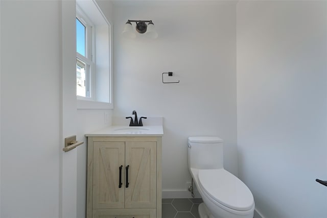 bathroom with tile patterned flooring, vanity, toilet, and plenty of natural light