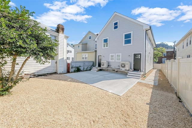 rear view of property with ac unit and a patio