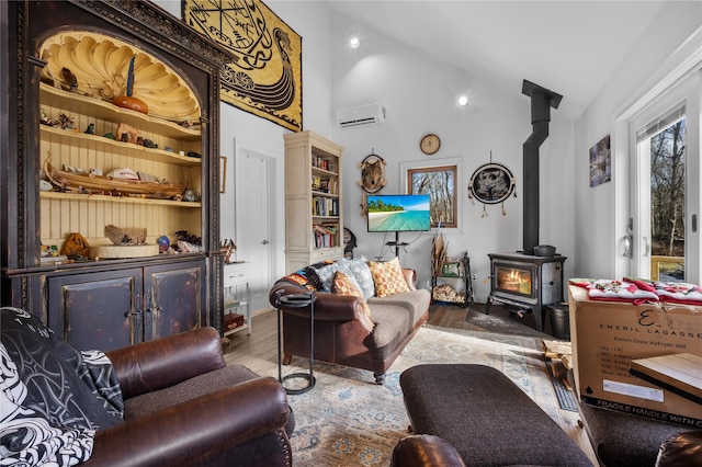 living room featuring high vaulted ceiling, a wall unit AC, wood finished floors, and a wood stove