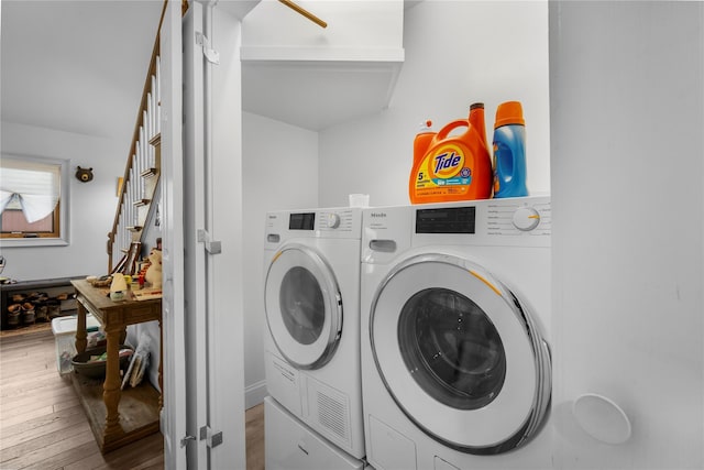 clothes washing area with hardwood / wood-style flooring and independent washer and dryer