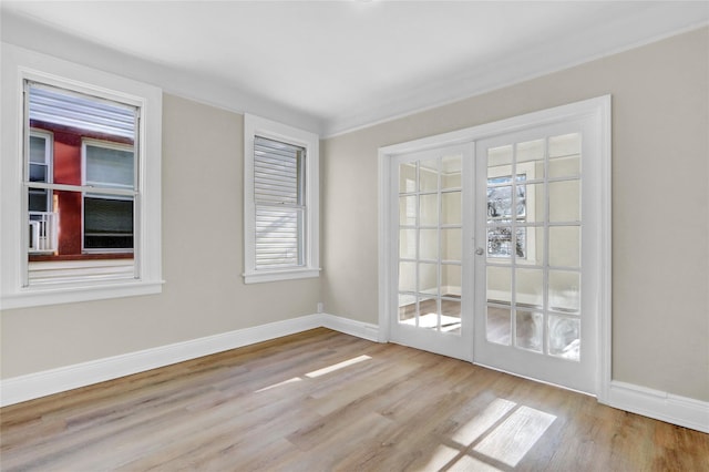 spare room with french doors and light hardwood / wood-style flooring