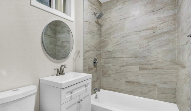 full bathroom with tiled shower / bath, vanity, and toilet