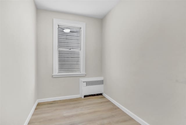 spare room featuring radiator and light wood-type flooring