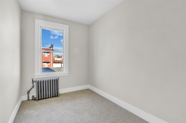 unfurnished room with radiator and carpet