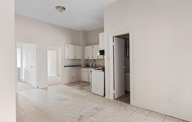 kitchen featuring decorative backsplash, range, white cabinetry, and exhaust hood