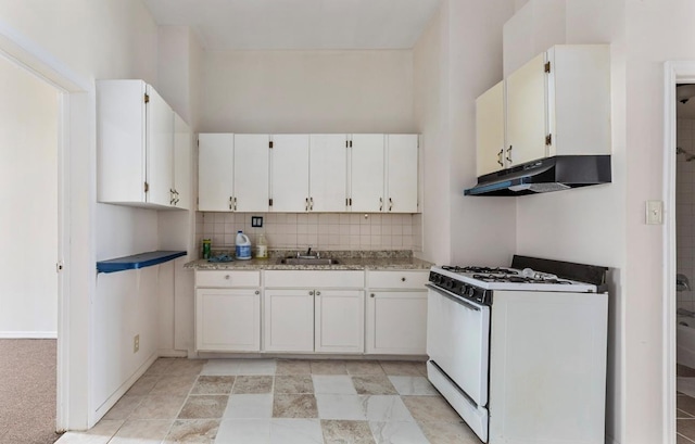 kitchen with gas range gas stove, sink, light stone countertops, backsplash, and white cabinets