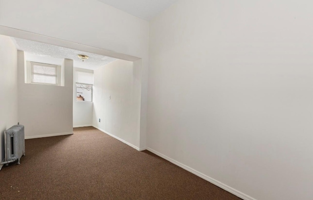 carpeted spare room featuring radiator