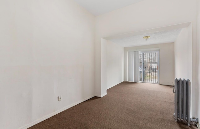 spare room with carpet flooring and radiator